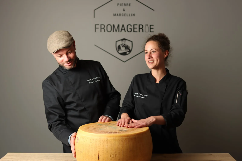 Les fromagers de Pierre & Marcellin avec une meule de fromage